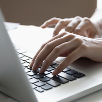 two hands typing on a laptop keyboard